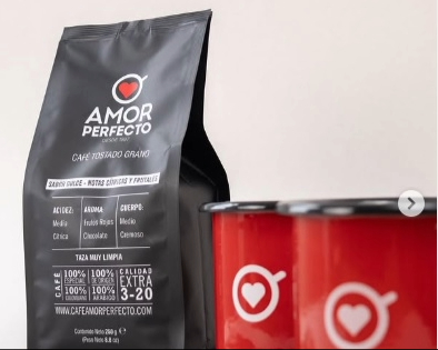 Un paquete negro de café con dos pocillos rojos.