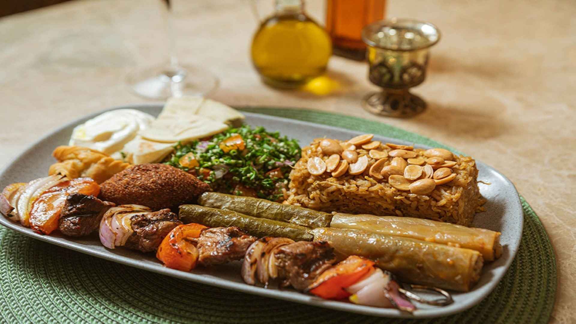 Un variado plato árabe con kebabs, kibbeh, tabule, arroz con almendras y hojas de parra rellenas.