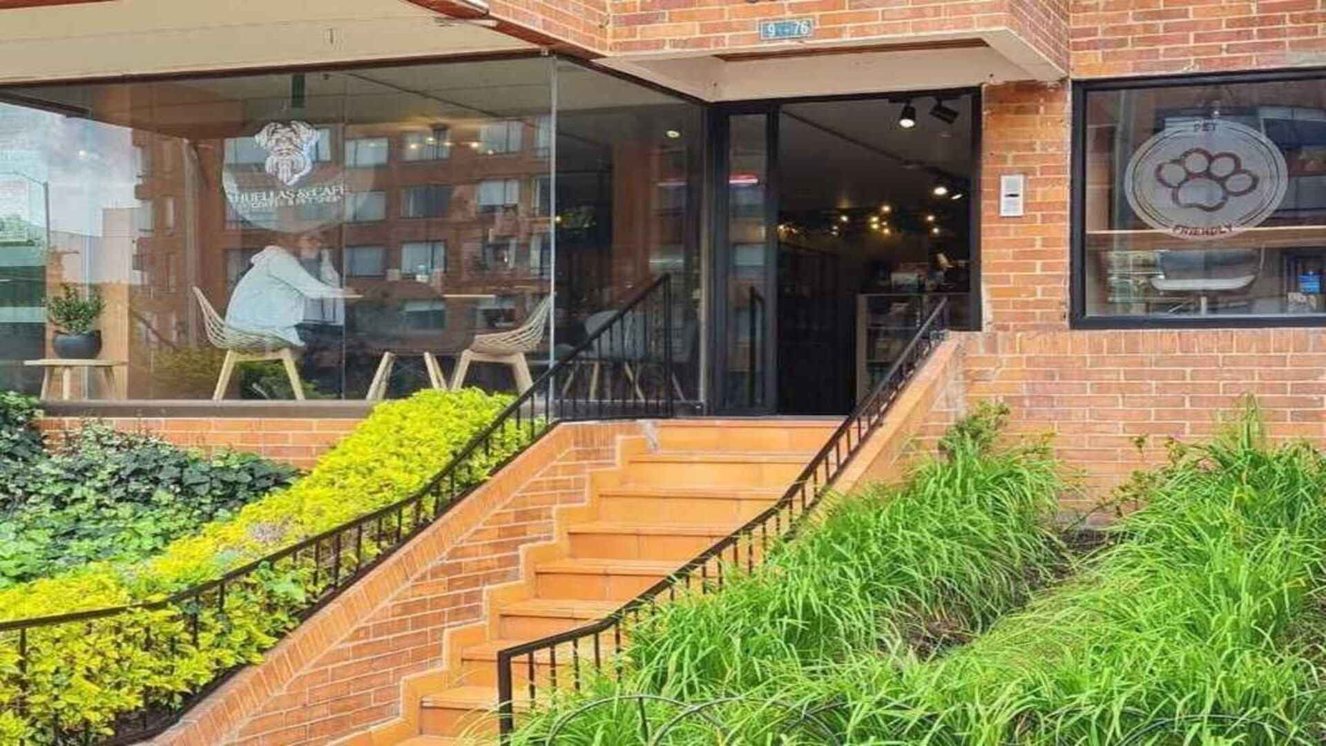 La entrada de "Huellas & Café", un lugar pet-friendly con una encantadora escalera y mucha vegetación.