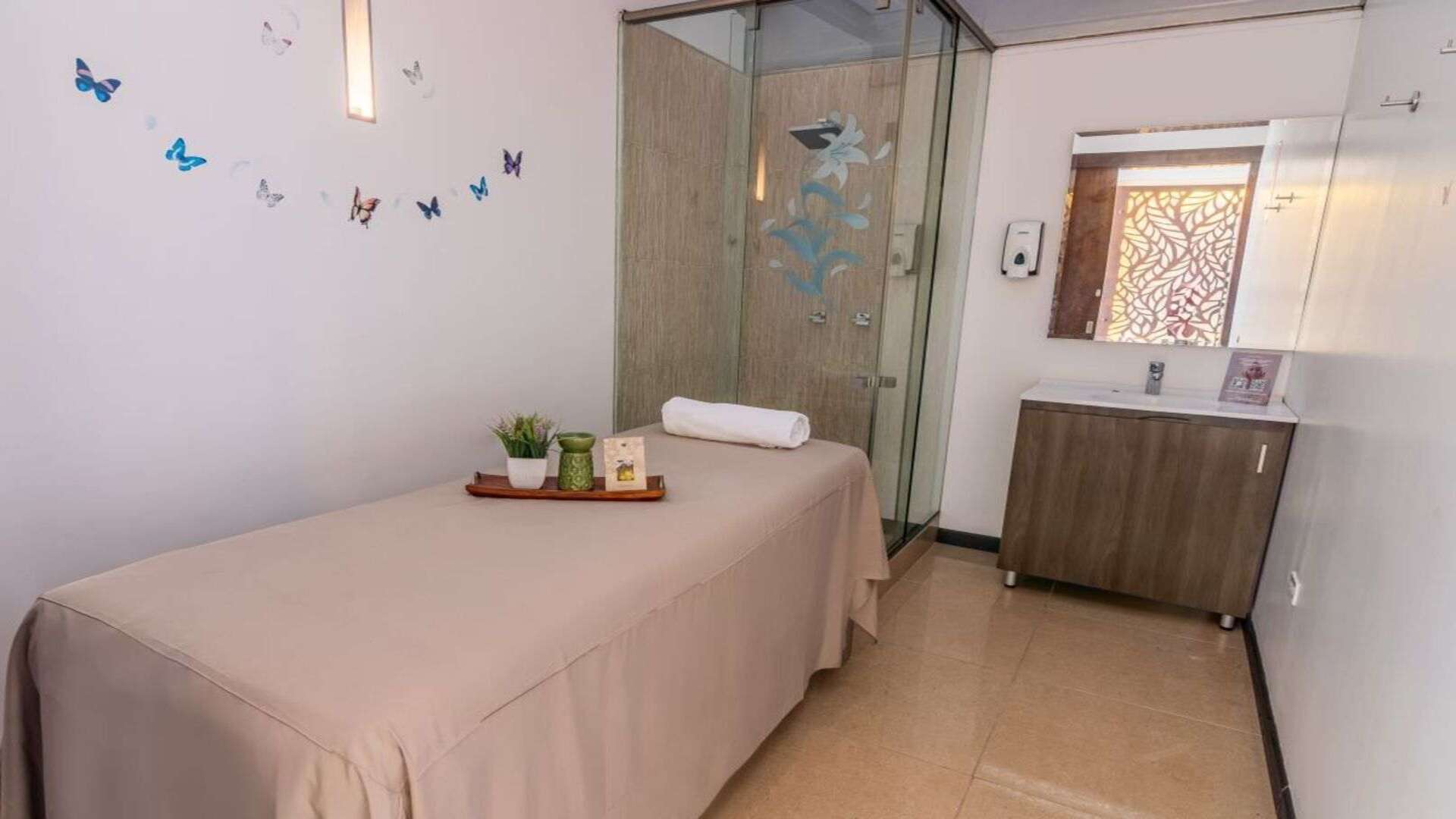 Habitación de hotel con cama king-size, cabecera gris acolchada y vistas exteriores.