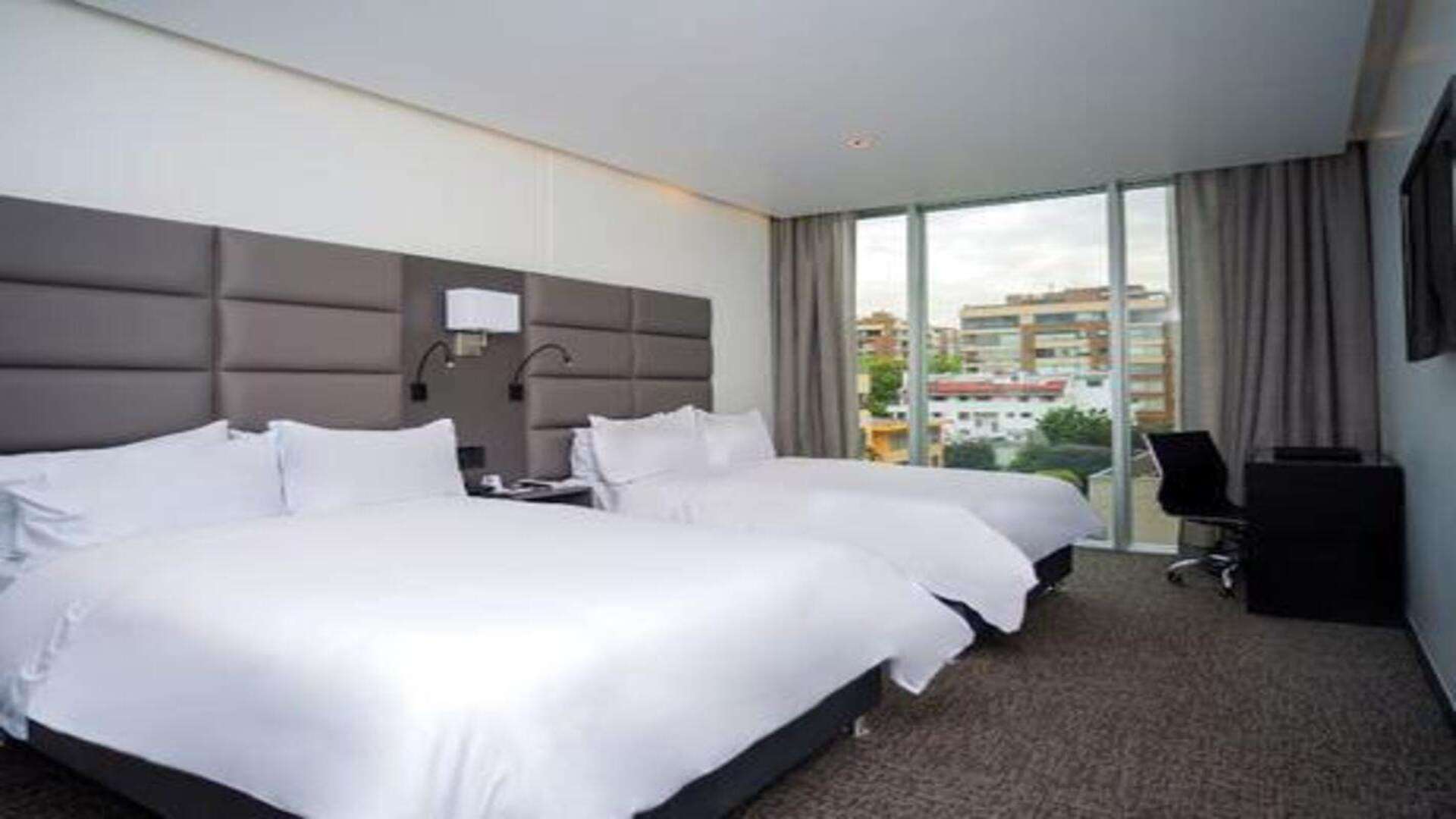  Sala de masajes con camilla, ducha de cristal y lavabo, decorada con mariposas.