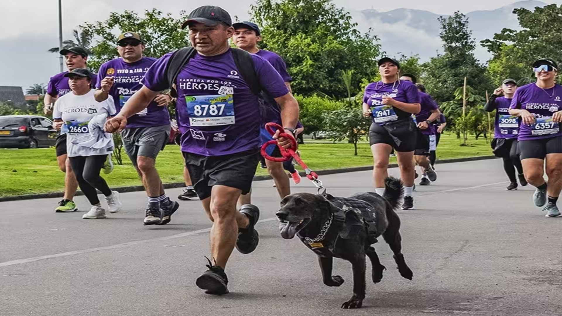 Un corredor y su fiel perro compiten juntos con entusiasmo durante la Carrera por los Héroes del año 2025.