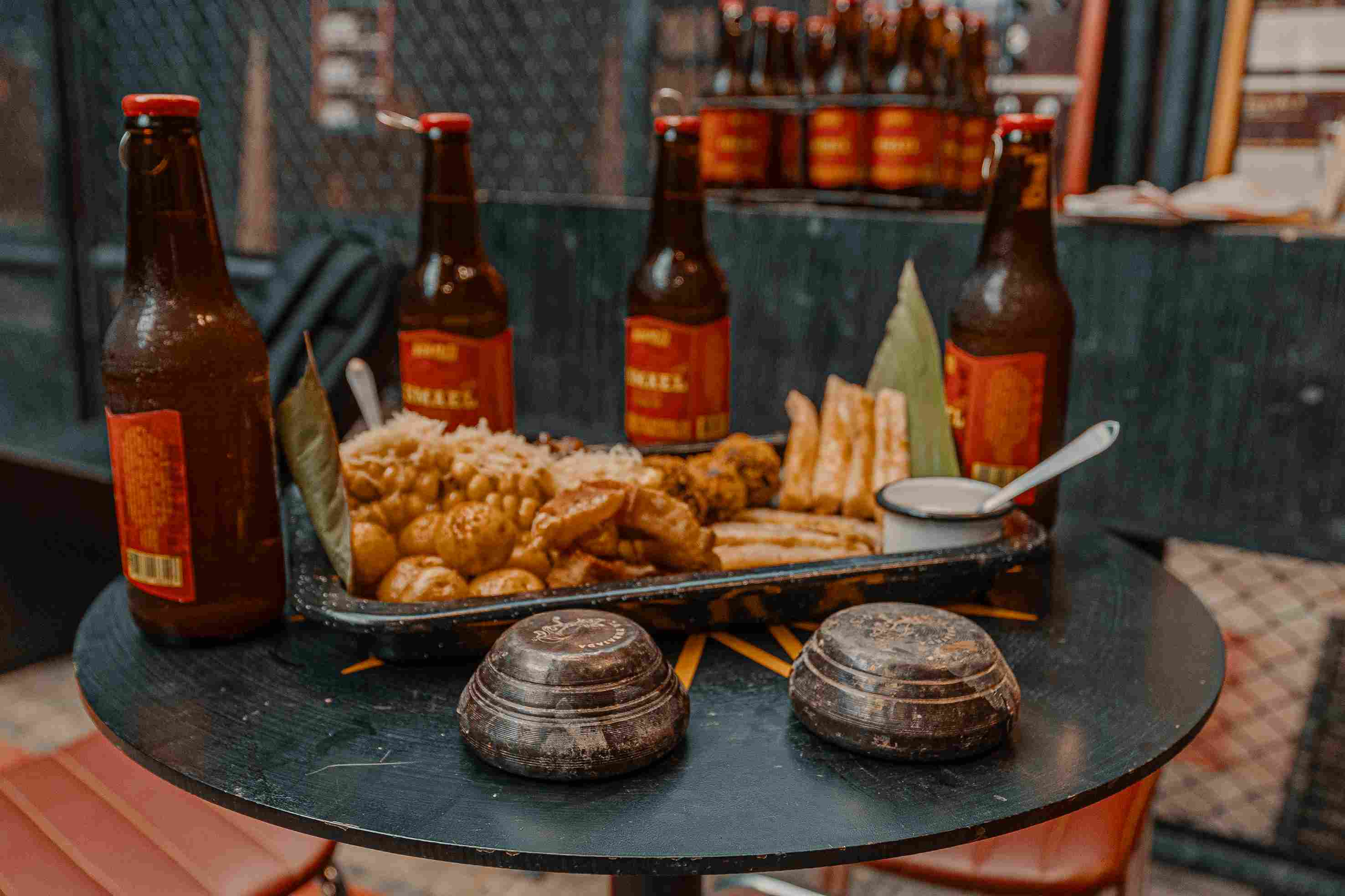 Vista elevada de un amplio espacio de eventos industrial con estructuras de malla metálica y una gran multitud de asistentes.
