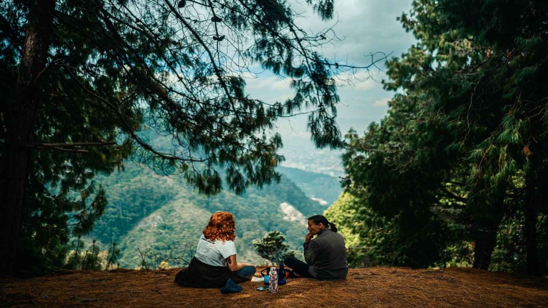  Dos mujeres dialogan y conectan con la naturaleza en los senderos de la Quebrada La Vieja en los cerros de Bogotá.
